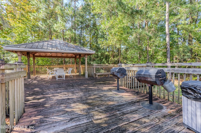 wooden terrace featuring a gazebo, area for grilling, and outdoor dining space