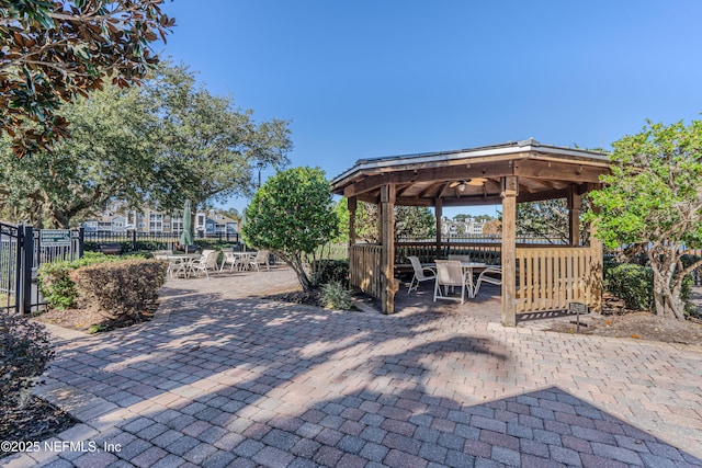 view of patio / terrace with a gazebo, outdoor dining space, and fence