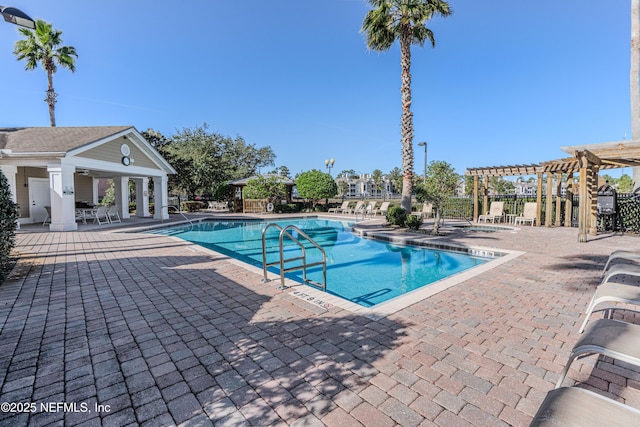 pool with an outbuilding, a patio area, and a pergola