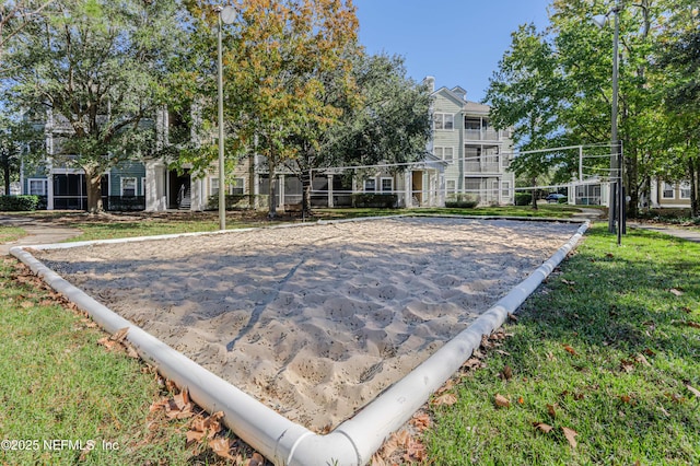 view of home's community featuring volleyball court and a lawn