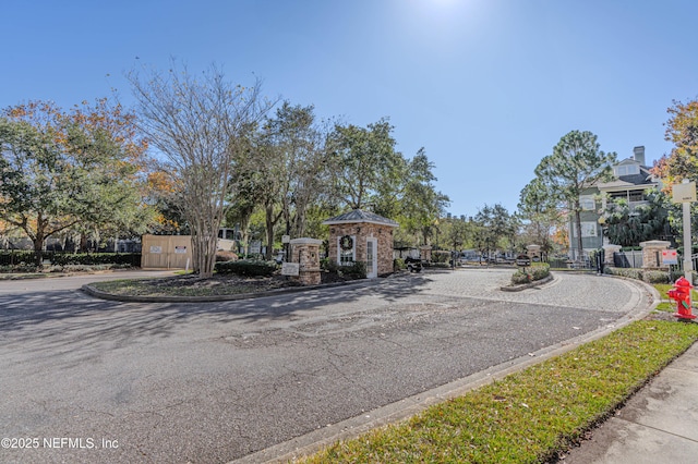 view of street with curbs and a gated entry