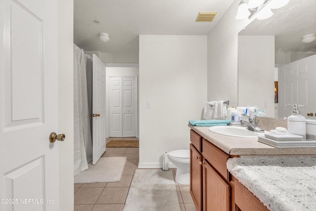 bathroom featuring tile patterned flooring, visible vents, baseboards, toilet, and vanity