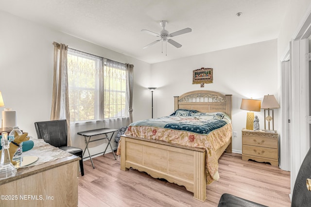 bedroom with ceiling fan and light wood-style floors