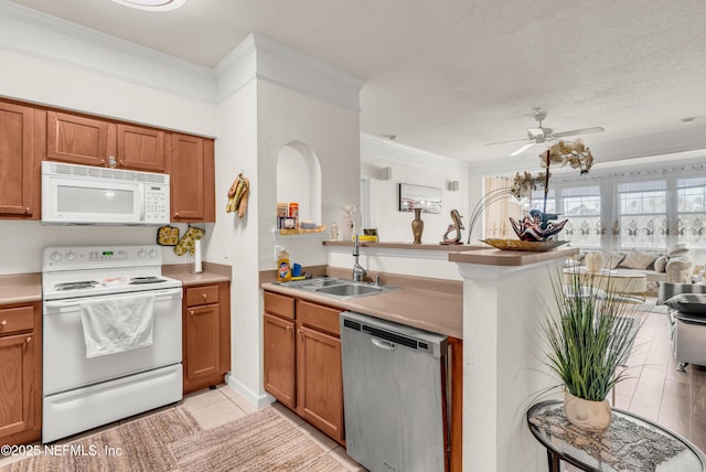 kitchen featuring ceiling fan, ornamental molding, light tile patterned floors, white appliances, and a sink