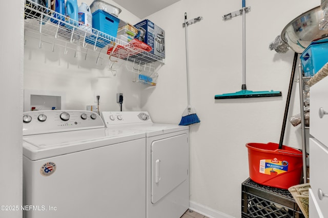 washroom featuring laundry area, washing machine and dryer, and baseboards