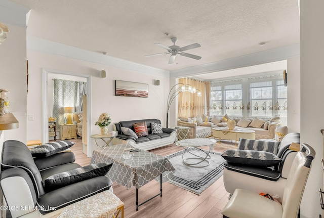 living area with wood finished floors, a ceiling fan, and a textured ceiling