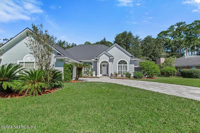 2619 Wrightson Dr, Jacksonville, FL 32223 - ranch-style home featuring stucco siding, curved driveway, and a front yard