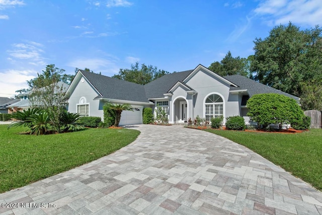 2619 Wrightson Dr, Jacksonville, FL 32223 - single story home featuring stucco siding, an attached garage, a front lawn, and decorative driveway
