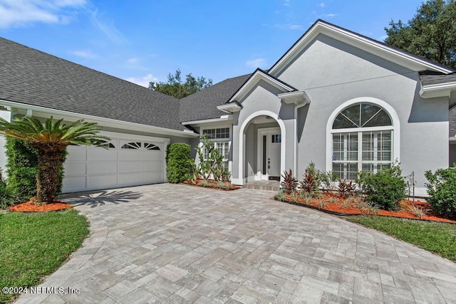 2619 Wrightson Dr, Jacksonville, FL 32223 - ranch-style house with stucco siding, an attached garage, and decorative driveway