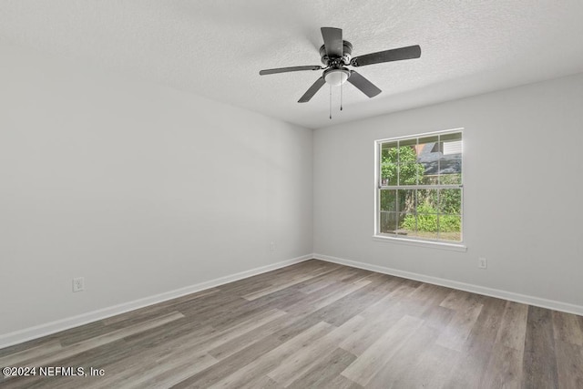 2619 Wrightson Dr, Jacksonville, FL 32223 - spare room with wood finished floors, a textured ceiling, a ceiling fan, and baseboards