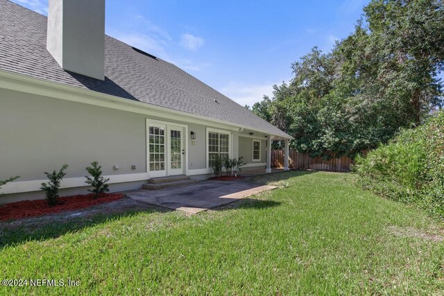 2619 Wrightson Dr, Jacksonville, FL 32223 - rear view of property with a chimney, fence, a yard, a patio area, and roof with shingles