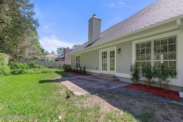 2619 Wrightson Dr, Jacksonville, FL 32223 - back of property with a chimney, fence, a patio, a lawn, and roof with shingles