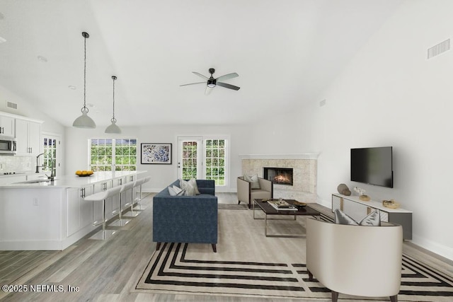 2619 Wrightson Dr, Jacksonville, FL 32223 - living room featuring high vaulted ceiling, a premium fireplace, a ceiling fan, light wood-style flooring, and visible vents