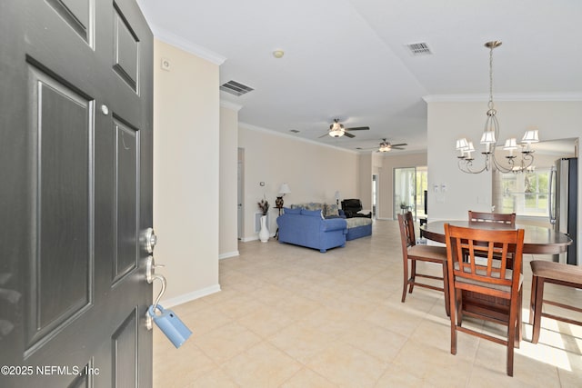 dining space featuring crown molding, ceiling fan with notable chandelier, visible vents, and baseboards