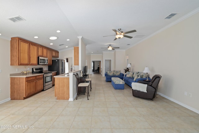 kitchen featuring a kitchen bar, open floor plan, visible vents, and stainless steel appliances