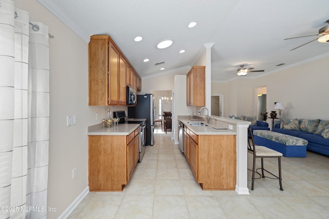 kitchen featuring open floor plan, stainless steel appliances, a ceiling fan, and a sink