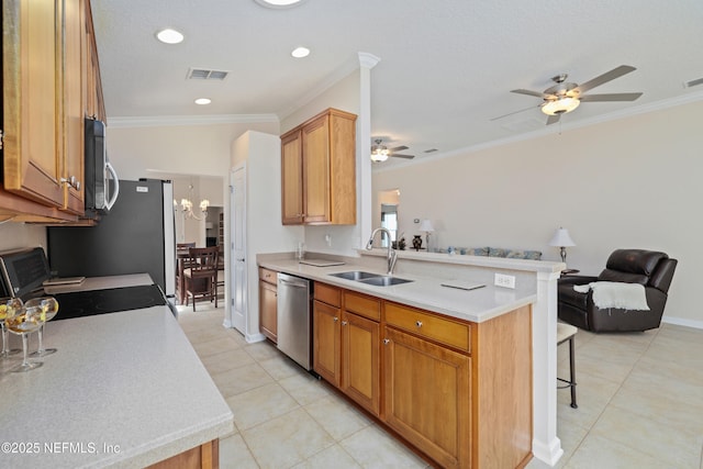 kitchen featuring open floor plan, light countertops, a kitchen breakfast bar, stainless steel appliances, and a sink