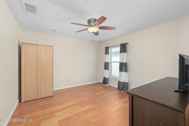 unfurnished office featuring light wood finished floors, visible vents, baseboards, and a ceiling fan