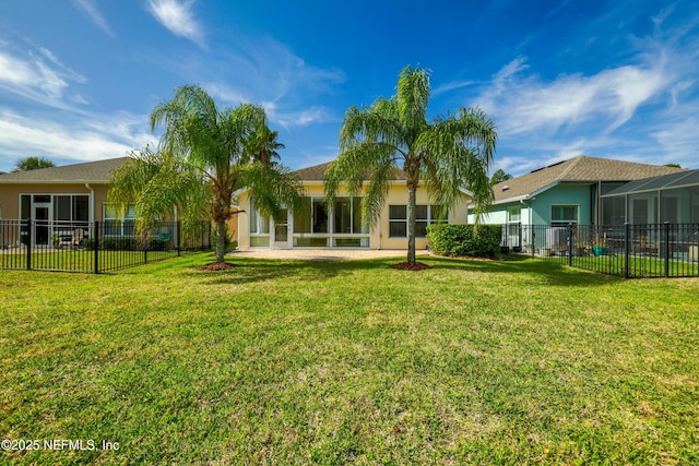 rear view of property featuring fence private yard, a lawn, and stucco siding