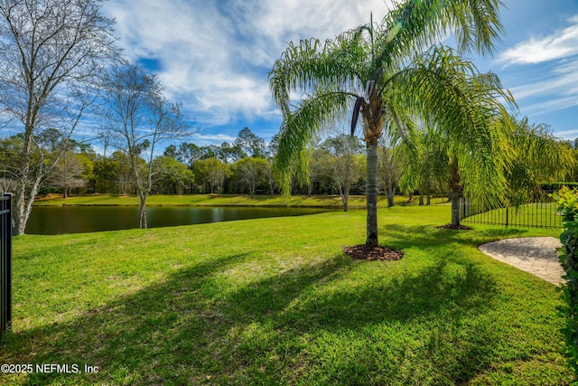 view of home's community with a water view and a lawn