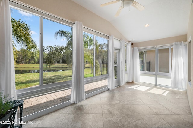 unfurnished sunroom featuring lofted ceiling, recessed lighting, a water view, and tile patterned floors