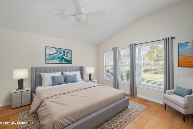 bedroom featuring vaulted ceiling, baseboards, and light wood finished floors