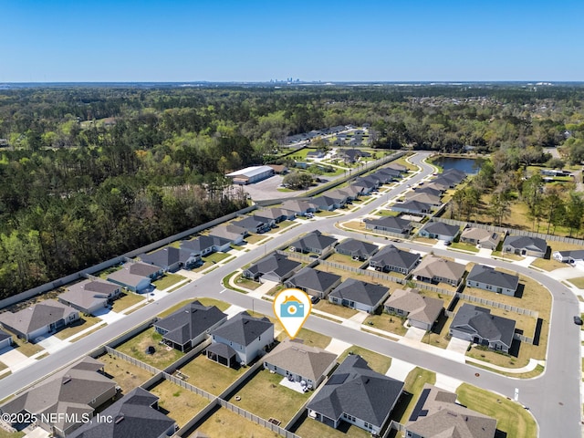 bird's eye view featuring a wooded view, a residential view, and a water view