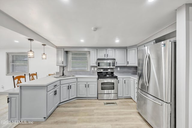 6099 Milligan Rd, Keystone Heights, FL 32656 - kitchen with light wood-type flooring, a sink, stainless steel appliances, a peninsula, and light countertops