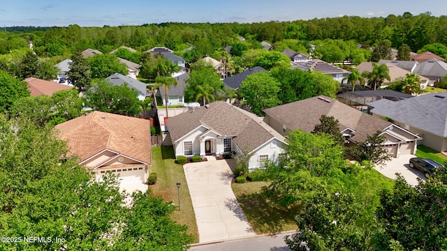 birds eye view of property featuring a forest view and a residential view