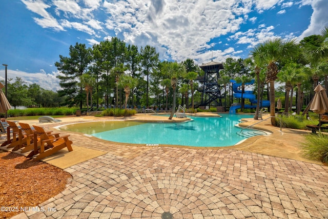 view of swimming pool featuring a patio and a water slide