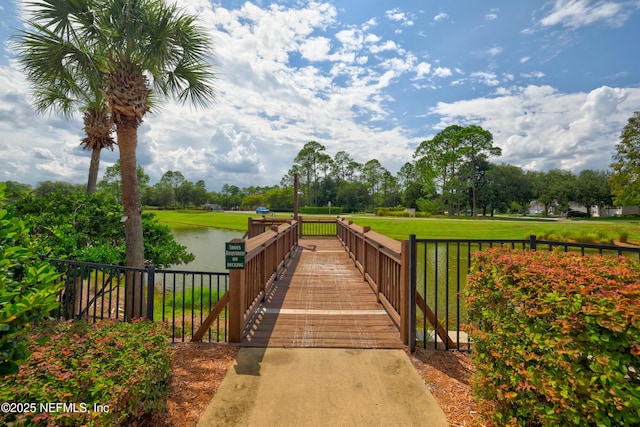 surrounding community with a water view and a yard