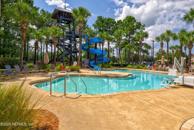 community pool featuring a patio area and a water slide