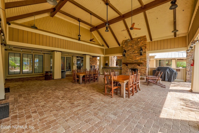 view of patio / terrace with outdoor dining space, an outdoor stone fireplace, a grill, visible vents, and ceiling fan