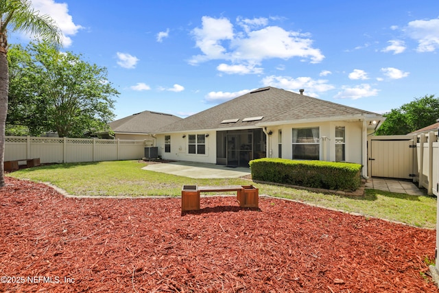 rear view of house featuring a patio, central AC unit, a fenced backyard, and a shingled roof