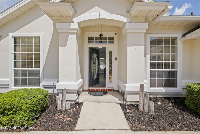 entrance to property featuring stucco siding