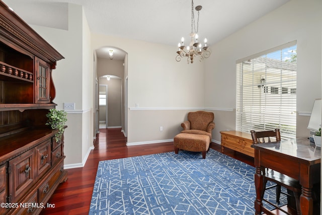 sitting room with a chandelier, arched walkways, wood finished floors, and baseboards