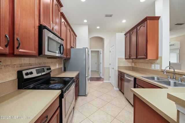 kitchen featuring light tile patterned flooring, a sink, visible vents, and stainless steel appliances