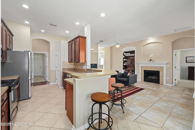 kitchen with a breakfast bar, a peninsula, open floor plan, visible vents, and stainless steel appliances