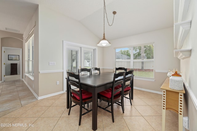 dining room featuring light tile patterned floors, baseboards, and lofted ceiling