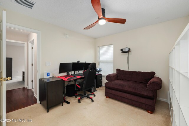 office area featuring visible vents, ceiling fan, carpet floors, and baseboards