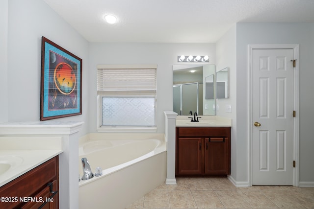 bathroom featuring two vanities, a shower stall, a bath, a sink, and tile patterned floors