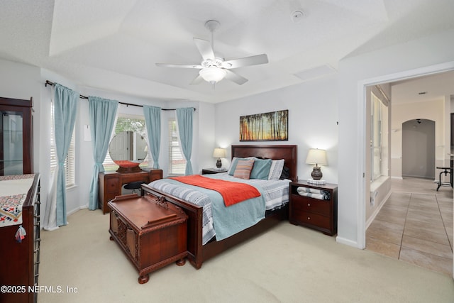 bedroom with light carpet, baseboards, light tile patterned flooring, and ceiling fan