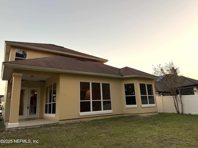 3549 Victoria Lakes Dr W, Jacksonville, FL 32226 - back of property featuring fence, a yard, a shingled roof, stucco siding, and a patio area