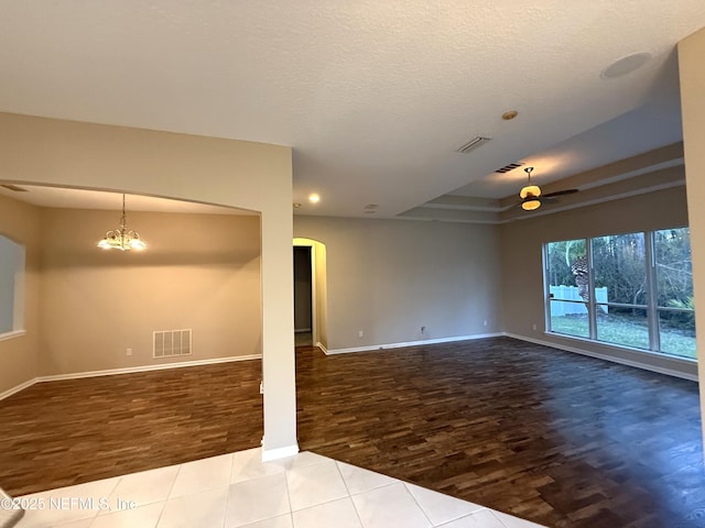 3549 Victoria Lakes Dr W, Jacksonville, FL 32226 - unfurnished living room with visible vents, arched walkways, wood finished floors, and ceiling fan with notable chandelier