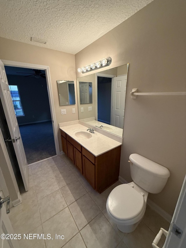 3549 Victoria Lakes Dr W, Jacksonville, FL 32226 - bathroom featuring vanity, baseboards, a textured ceiling, tile patterned floors, and toilet
