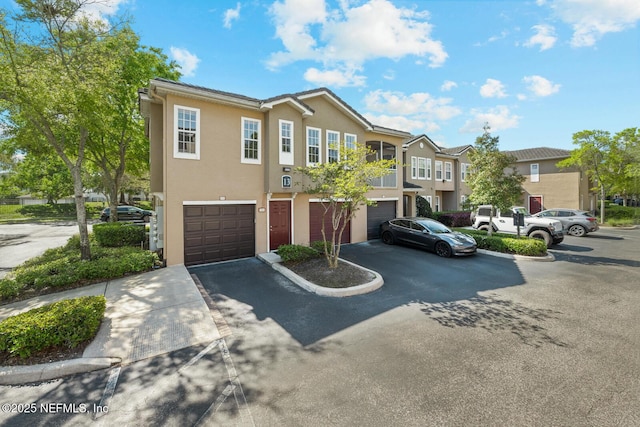 10075 Gate Pkwy Unit 1301, Jacksonville, FL 32246 - view of property with stucco siding, a residential view, driveway, and an attached garage