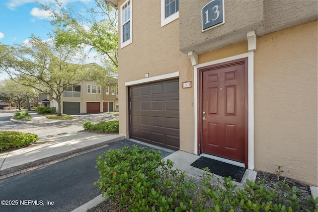 10075 Gate Pkwy Unit 1301, Jacksonville, FL 32246 - doorway to property with an attached garage and stucco siding