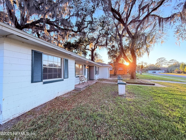 view of home's exterior with concrete block siding and a yard