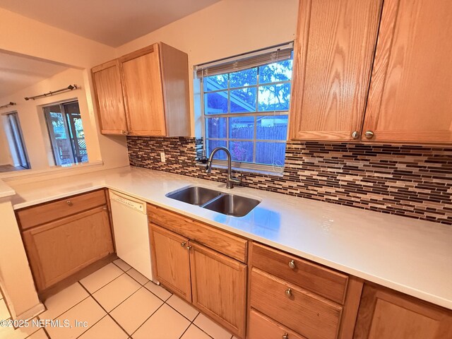 kitchen featuring a sink, tasteful backsplash, light tile patterned flooring, light countertops, and dishwasher