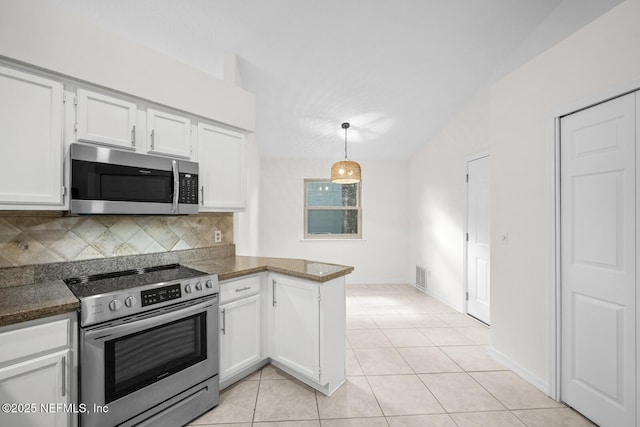 kitchen with appliances with stainless steel finishes, white cabinets, backsplash, and a peninsula